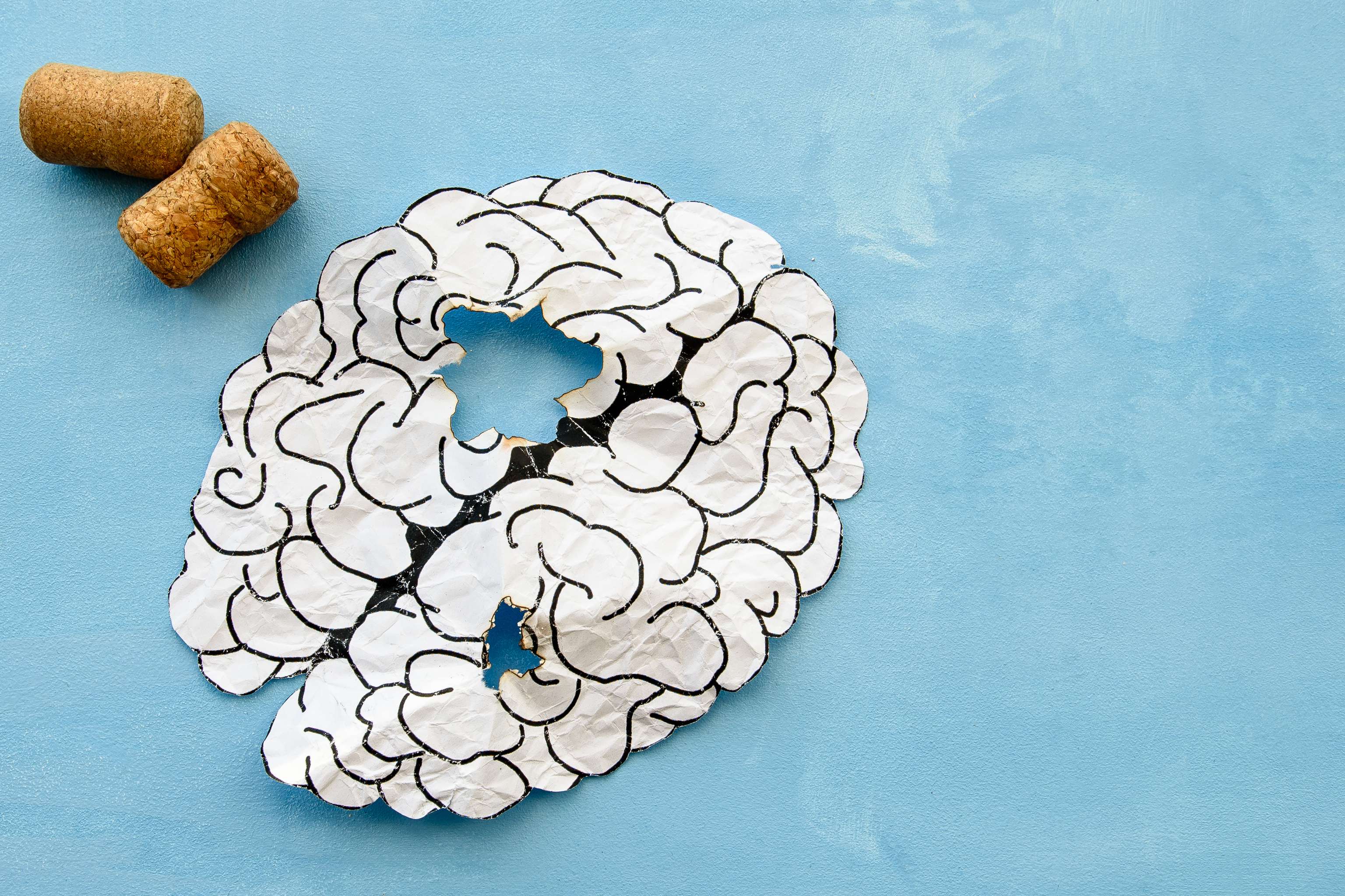 O cérebro humano sobre um fundo azul é o início da dependência do álcool. Proteção da saúde mental Diminuição do volume cerebral devido ao álcool