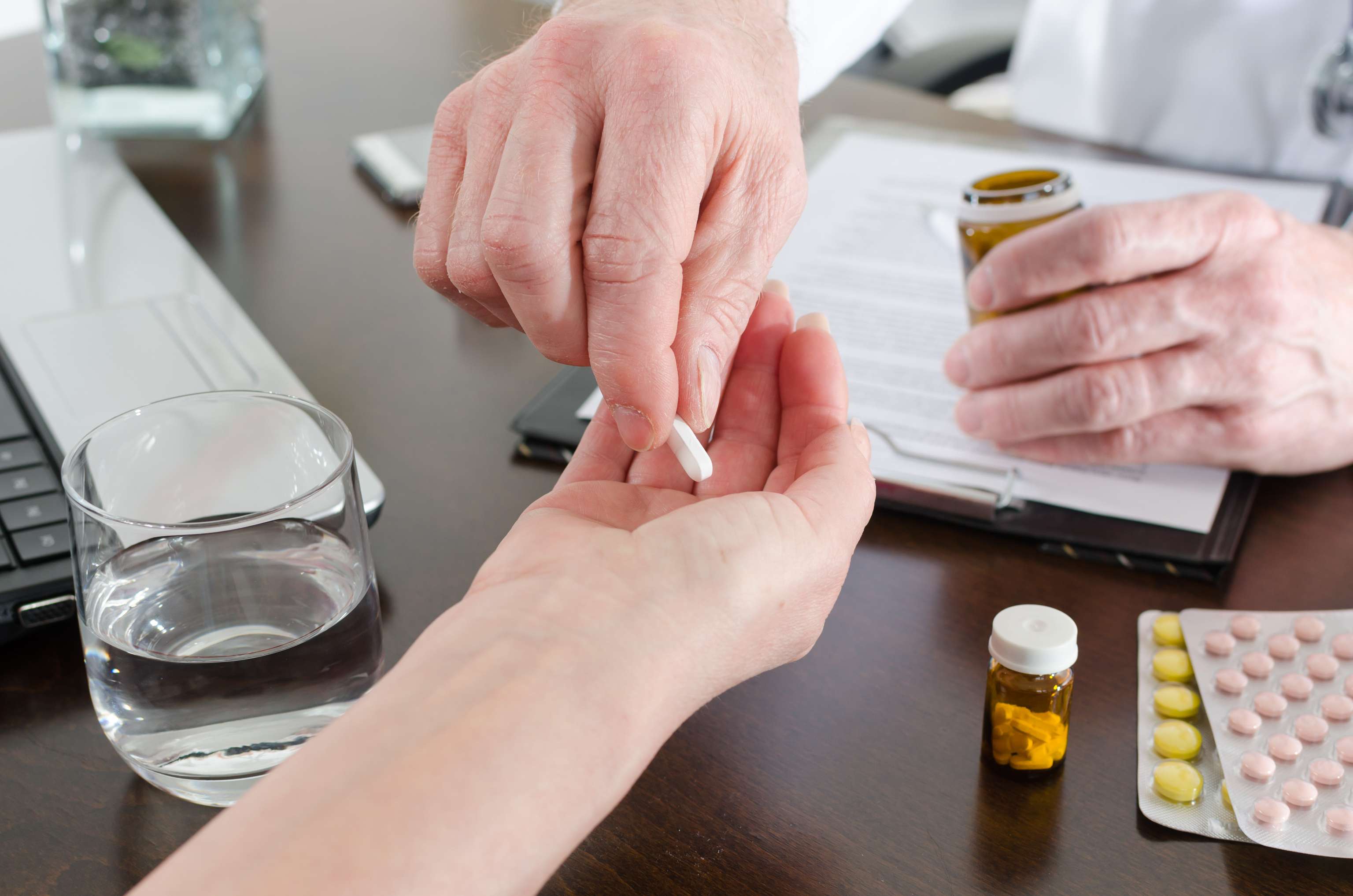 Doctor give a tablet for his patient Doctor gives patient a tablet in hand