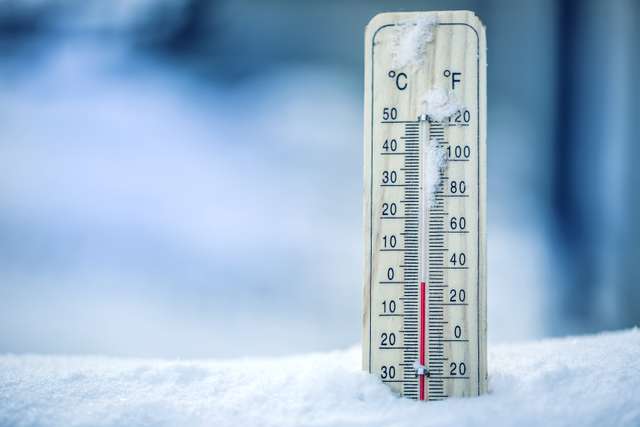 A thermometer on snow shows low temperatures in Celsius and Fahrenheit. The thermometer on snow shows low temperatures in Celsius or Farenheit.