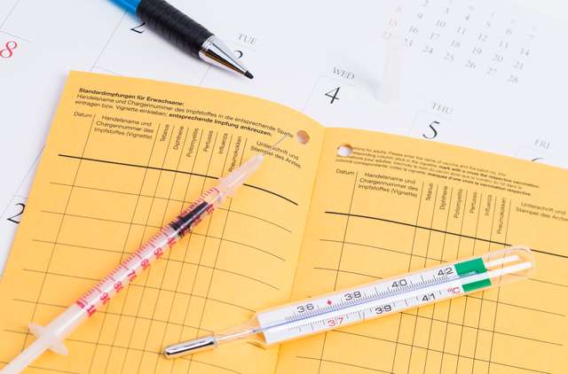 Inoculation and voucher - stock photo Vaccination certificate with thermometer and syringe