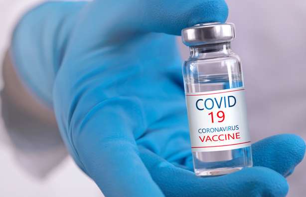 Desarrollo y producción de una vacuna contra el coronavirus Un médico sostiene una vacuna COVID-19 en la mano