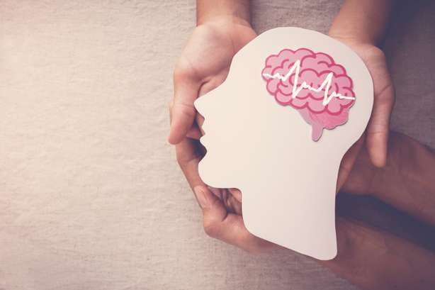 Adultes et enfants ayant une encéphalographie du cerveau, papier découpé, épilepsie et conscience de la maladie d'Alzheimer, convulsions, concept de santé mentale Deux paires de mains tenant une tête découpée dans du papier avec un cerveau dessiné avec une encéphalographie symbolique pour symboliser l'épilepsie.